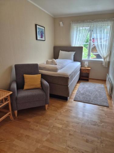 a bedroom with a bed and a couch and a chair at Apartment, Rekkedal Gjestegard - Sæbø in Ørsta