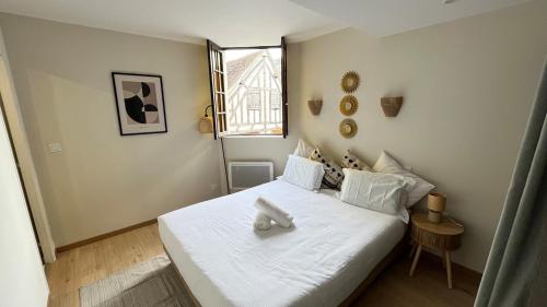 a bedroom with a white bed with a bow on it at Duplex Signature - Downtown - Sens in Sens
