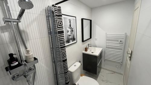a bathroom with a shower and a toilet and a sink at Duplex Signature - Downtown - Sens in Sens