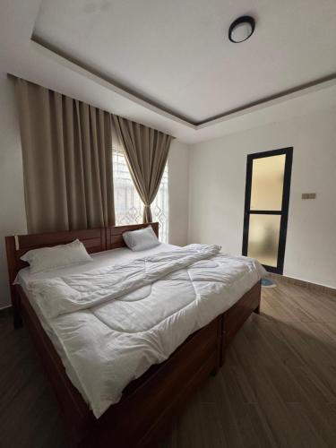 a bedroom with a large bed with a window at Kili Maisha Grand Home in Moshi