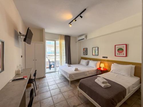a hotel room with two beds and a desk at Seagull apartments - A in Paralia Katerinis