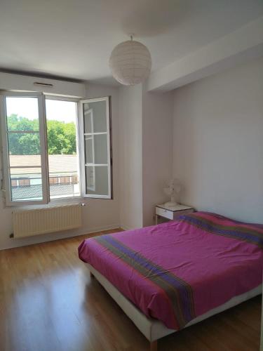 a bedroom with a purple bed and two windows at Tréfilerie in Saint-Étienne
