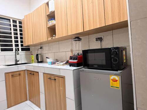 a kitchen with a microwave on top of a refrigerator at Maatambaba Homes in Tamale