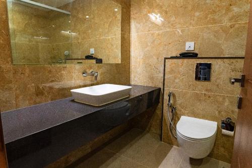 a bathroom with a sink and a toilet at HOTEL VKJ INN Aluva in Alwaye