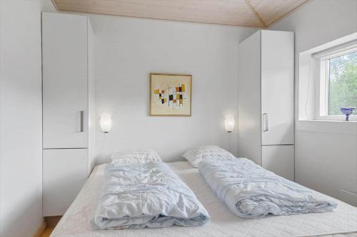 a white bedroom with two beds and a window at LF229-Vestervig-Hannesvej-16 in Vestervig