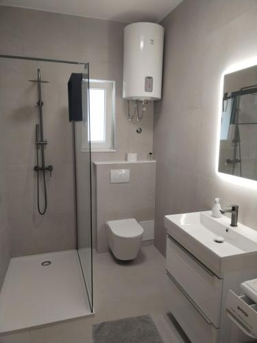 a bathroom with a toilet and a sink and a shower at Apartman Perkovic in Šibenik