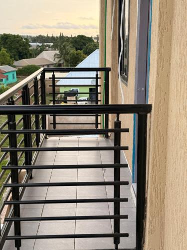 a balcony with black railings and a table on a balcony at Maatambaba Homes in Tamale