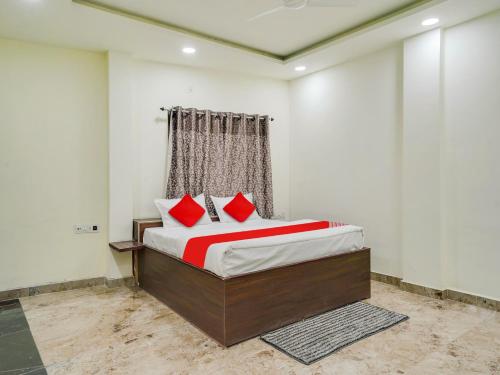 a bedroom with a bed with red pillows on it at HOTEL O M J HEIGHTS in Garhā