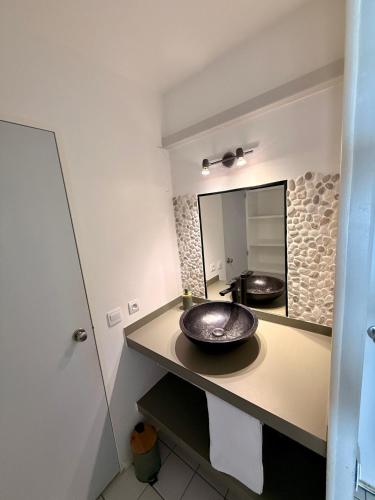 a bathroom with a sink and a mirror at Studio Vigie 212 vue mer, accès piscine in Le Diamant
