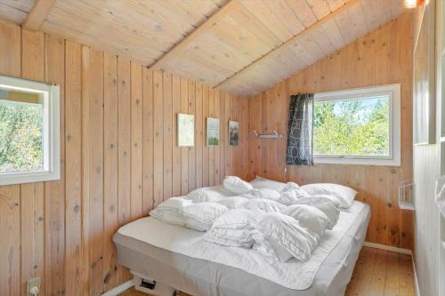 a bedroom with a large bed in a wooden wall at 0008-Romo-Froidal-24 in Høm