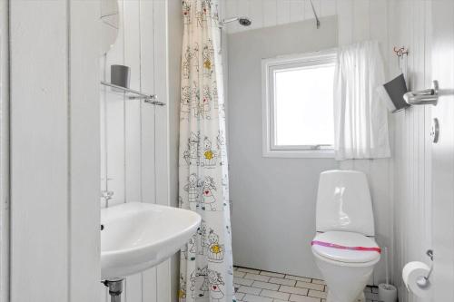 a white bathroom with a toilet and a sink at 0008-Romo-Froidal-24 in Høm