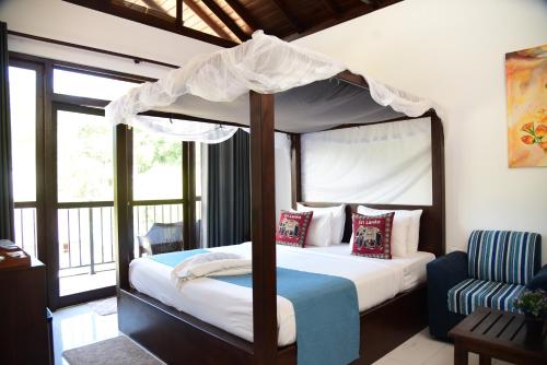 a bedroom with a canopy bed and a chair at Ever Breeze Ella Hotel in Ella
