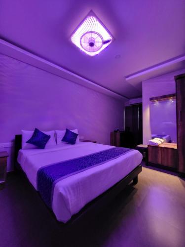 a purple bedroom with a large bed in a room at Hotel Grand Vista in Cochin