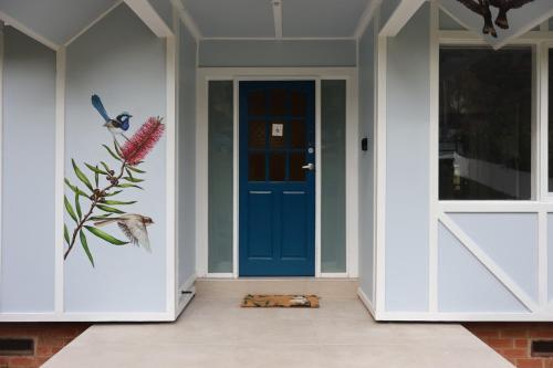 a blue door on a house with a cat on the floor at The Blue Wren in Blackheath