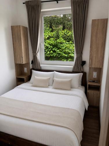 a bedroom with a large white bed with a window at V44 Resort in Visegrád
