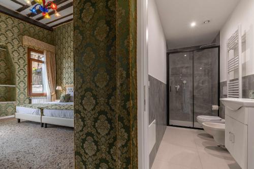 a bathroom with a shower and a toilet and a bed at Rialto Charm Boutique in Venice