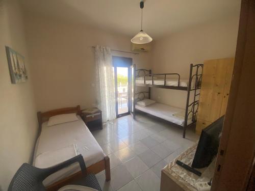 a room with two bunk beds and a television at Eleftheria House in Vourvourou