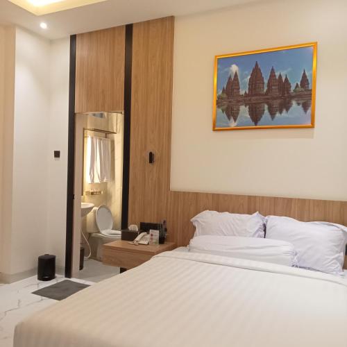 a hotel room with a bed and a bathroom at NH Residence Yogyakarta in Ngabean