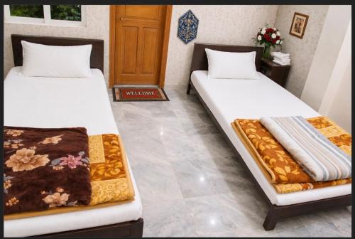 two beds sitting next to each other in a room at AGH Guesthouse & Rooms in Islamabad