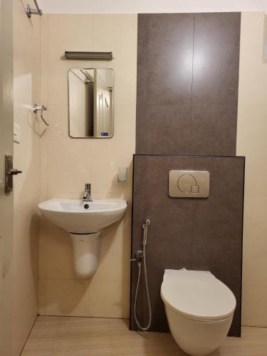 a bathroom with a toilet and a sink at Hotel Grand Vista in Cochin