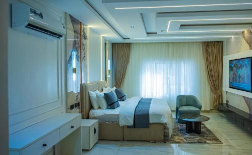 a hotel room with a bed and a television at Ocean Front Hotels Enugu in Awkuzu