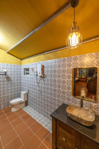a bathroom with a sink and a mirror and a toilet at Sunset Valley Dalat in Khu Chi Lăng