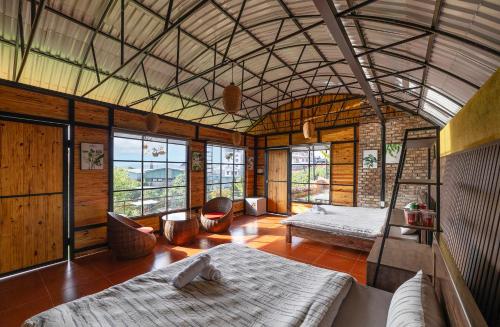 a room with two beds in a room with windows at Sunset Valley Dalat in Khu Chi Lăng