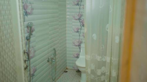 a bathroom with a toilet and flowers on the wall at The Cloud9 Villa in Tezpur