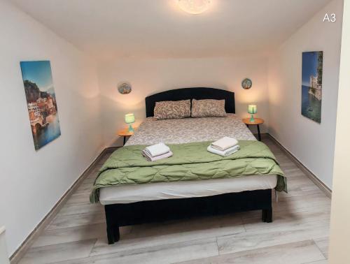 a bedroom with a bed and two lamps on two tables at Apartments Bardak in Ližnjan
