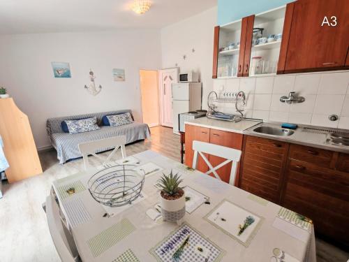 a kitchen and a living room with a table at Apartments Bardak in Ližnjan