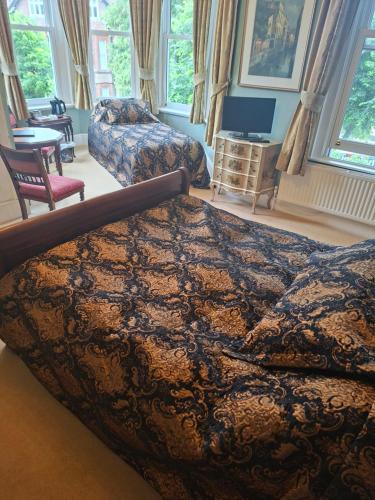 a bedroom with a bed and a couch and a chair at Beggar's Knap in Dorchester