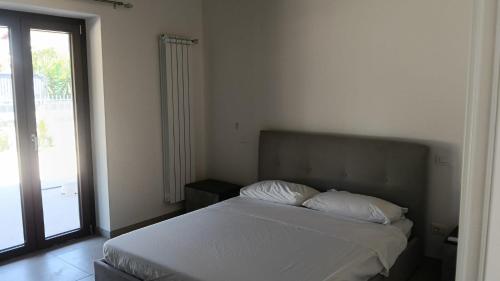 a bedroom with a bed with white sheets and a window at Oasi 29 in Morlupo