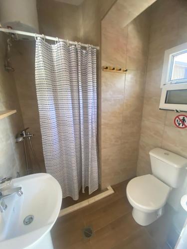 a bathroom with a white toilet and a sink at Eleftheria House in Vourvourou
