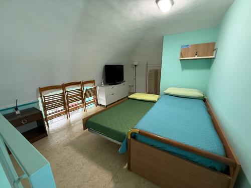 a bedroom with two beds and a tv and chairs at Domus Lucrezia in Bisceglie