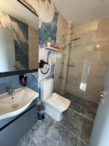 a bathroom with a toilet and a sink and a shower at Malta Bodrum in Bodrum City
