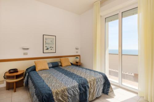 a bedroom with a bed and a large window at Hotel Man in Lido di Savio