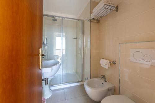 a bathroom with a toilet and a sink and a shower at Hotel Man in Lido di Savio