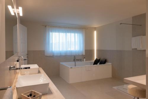 a bathroom with a white tub and a sink at Hotel Nibaru in Porto Cervo