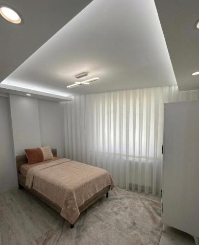 a bedroom with a bed in a room with curtains at İkizler villa in Edirne