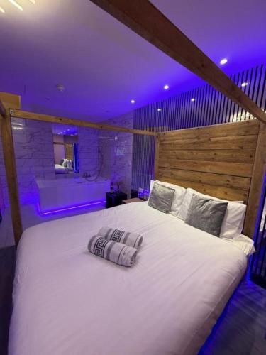 a large white bed in a room with purple lights at Mansa Halifax in Halifax