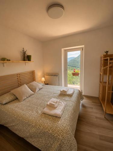 a bedroom with a bed with two towels on it at La casina di Viola in Posticciola