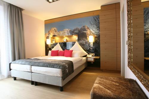 a hotel room with a large bed with red pillows at Congress Hotel am Stadtpark in Hannover