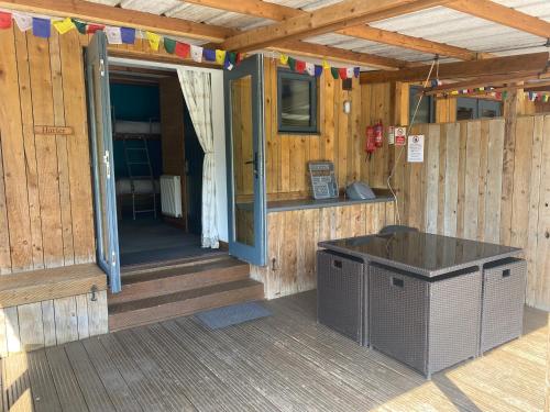 a front porch of a wooden cabin with a door at Cosy Glamping In the Eskdale Valley - Studio Lodges and Mega Pods in Eskdale