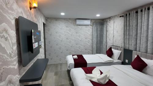 a hotel room with two beds and a tv at Bhandari hotel and sekuwa corner in Pashupatināth