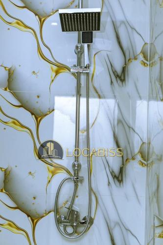 a shower head in a bathroom with a glass wall at Casa-Branca Pelundo in Rufisque