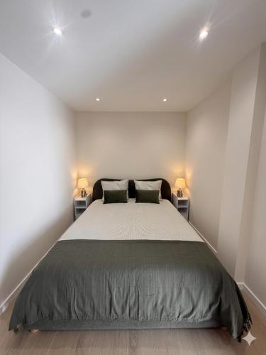 a bedroom with a large bed with two lamps at Vila Sotto Mayor in Figueira da Foz
