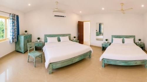 two beds in a room with two tables and two beds sidx sidx sidx at Sky Mount Villa in Mount Ābu