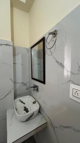 a white bathroom with a sink and a mirror at Northbound Kasol in Kasol