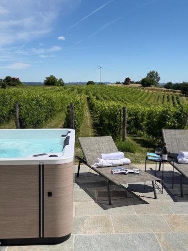 a hot tub on a patio in front of a vineyard at Braida Wine Resort in Rocchetta Tanaro