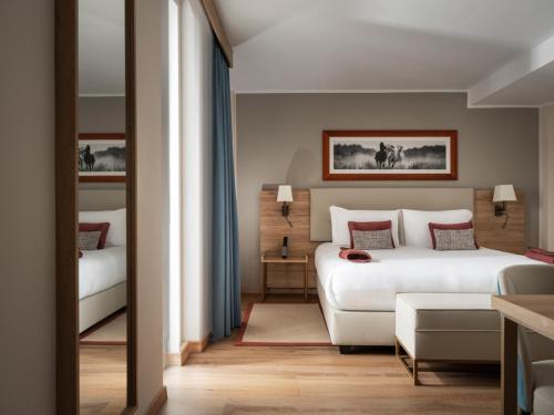 a bedroom with a bed and a couch in a room at Hotel Livata Mountain Wellness in Subiaco